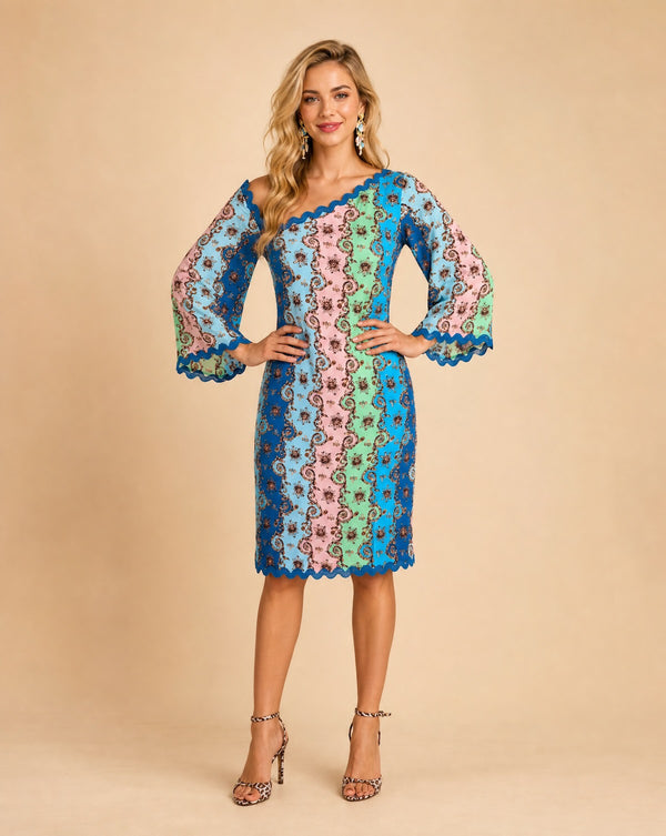 Model wearing Sophie green printed bell sleeve midi dress by Sandhya Garg, front view showing Versailles-inspired scrollwork print in blue, pink, mint, and teal vertical panels with scalloped lace hem and asymmetric neckline