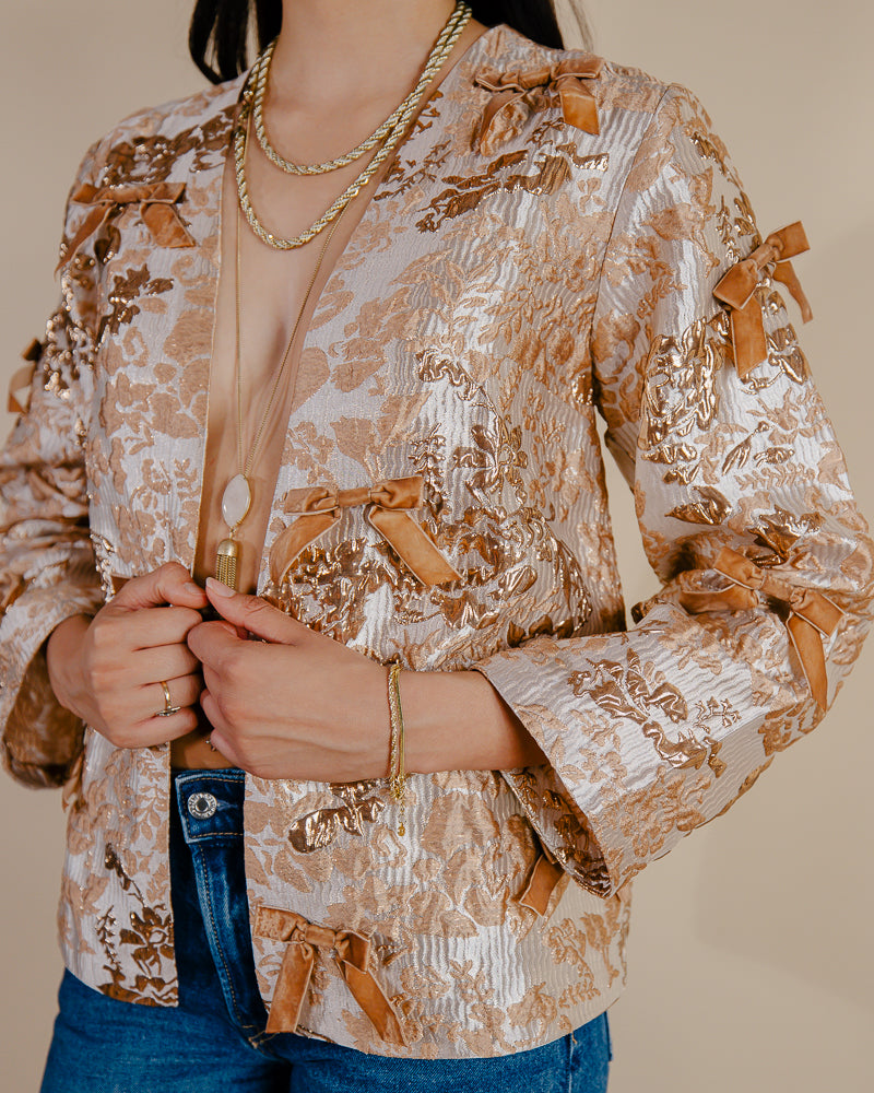 Sandhya Garg Agra gold jacquard jacket styled for occasion — showing loose mid-hip silhouette and multiple velvet bow detail