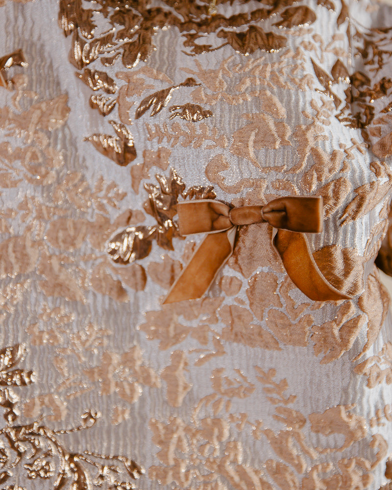 Close view of velvet bow detail on Sandhya Garg Agra gold jacquard jacket — showing small velvet bow placement and contrast texture against gold woven jacquard
